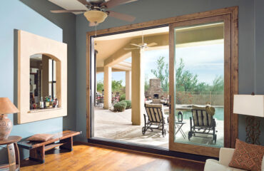 An open sliding glass door leading to a backyard