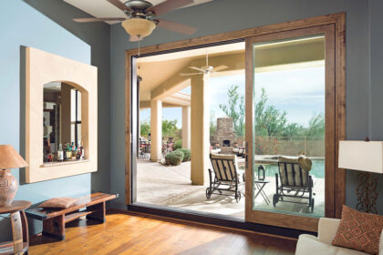 An open sliding glass door leading to a backyard