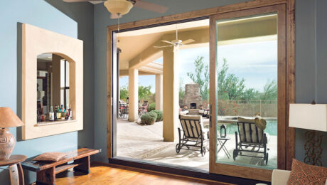 An open sliding glass door leading to a backyard