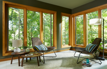 casement windows with wood veneer slightly open to a forested area