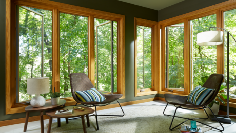 casement windows with wood veneer slightly open to a forested area