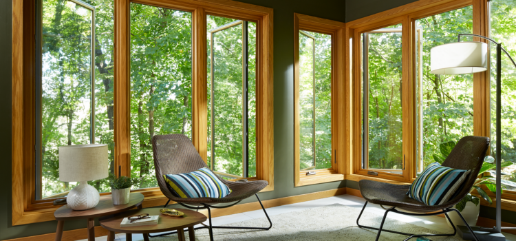 casement windows with wood veneer slightly open to a forested area